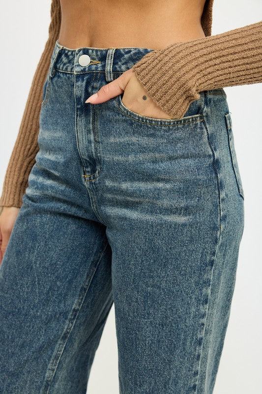 Close-up of fold-over waistband design on washed denim pants