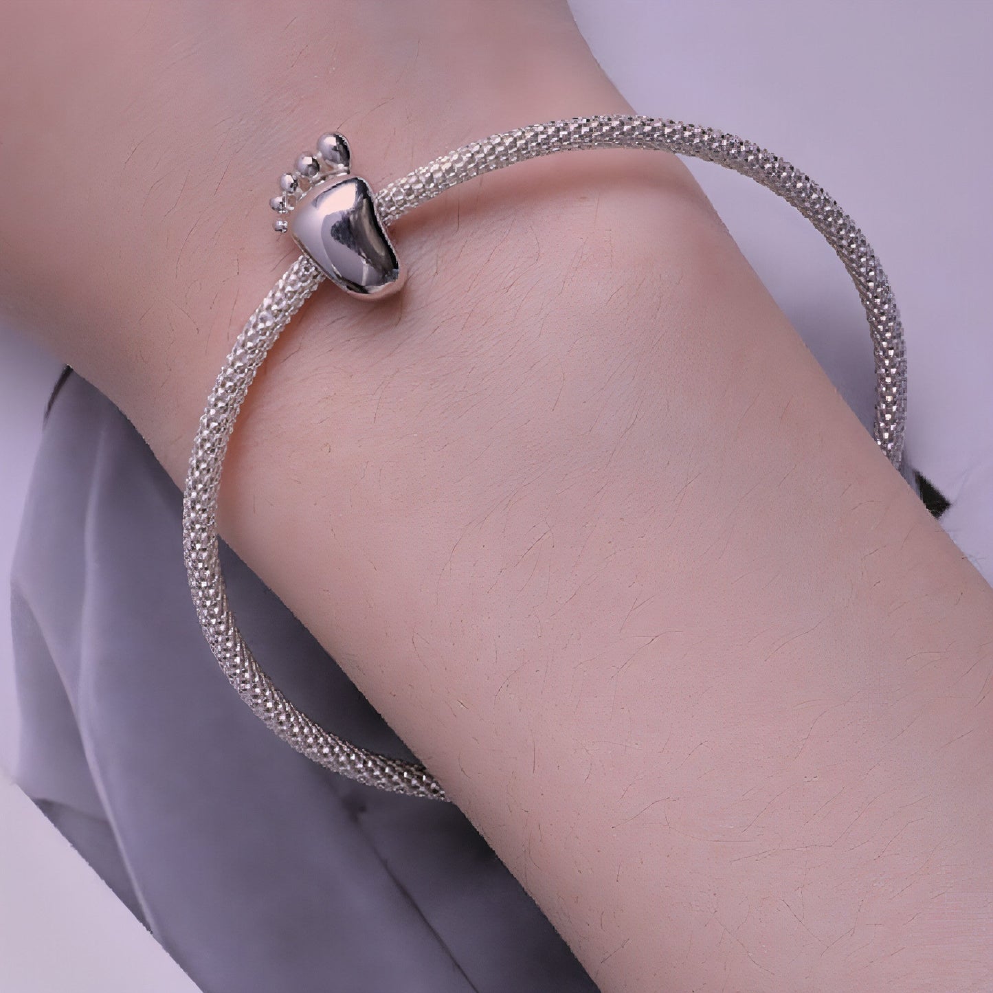 Close-up of silver baby footprint charm for bracelets
