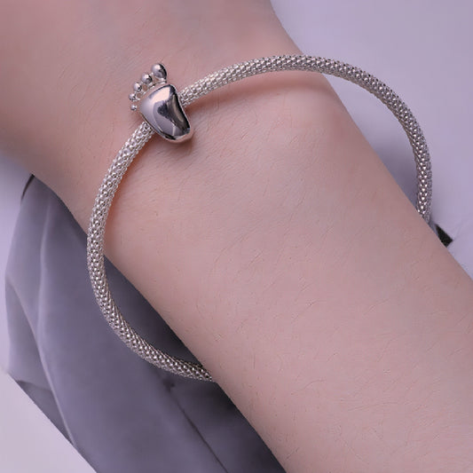 Close-up of silver baby footprint charm for bracelets