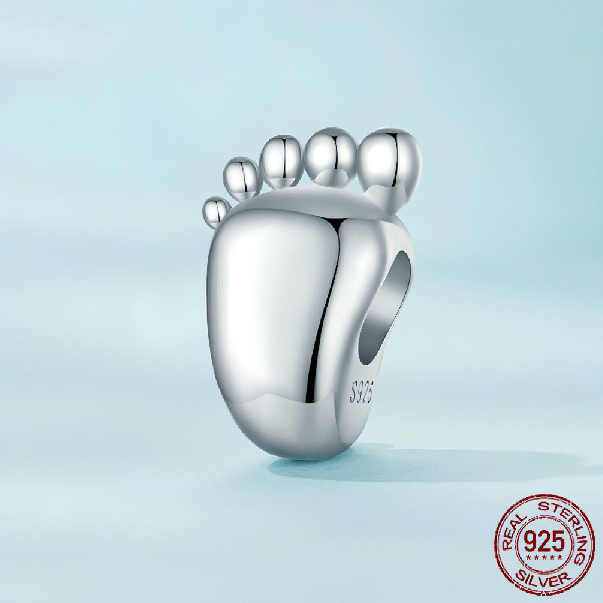 Baby footprint charm lying on soft gift pouch
