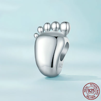 Baby footprint charm lying on soft gift pouch
