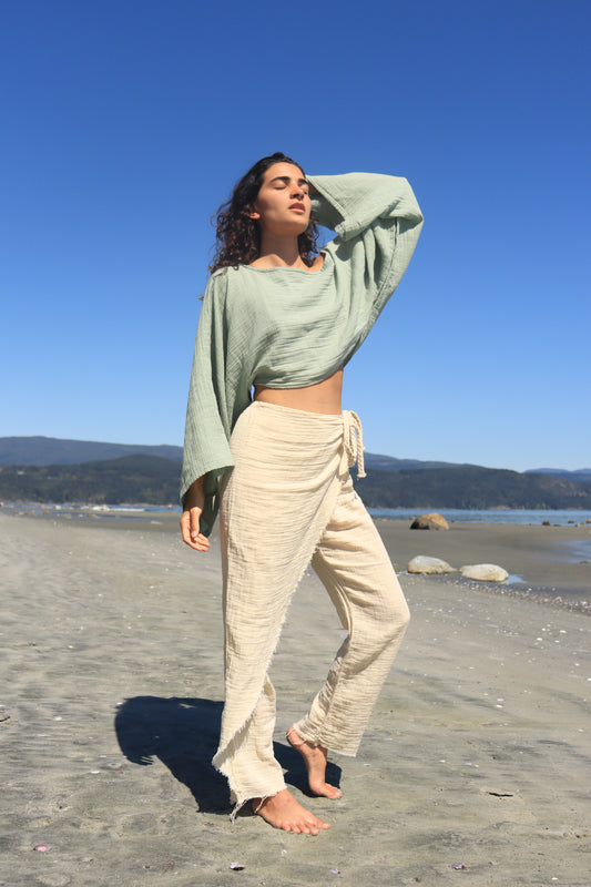 Side angle of model walking barefoot in organic cotton pants