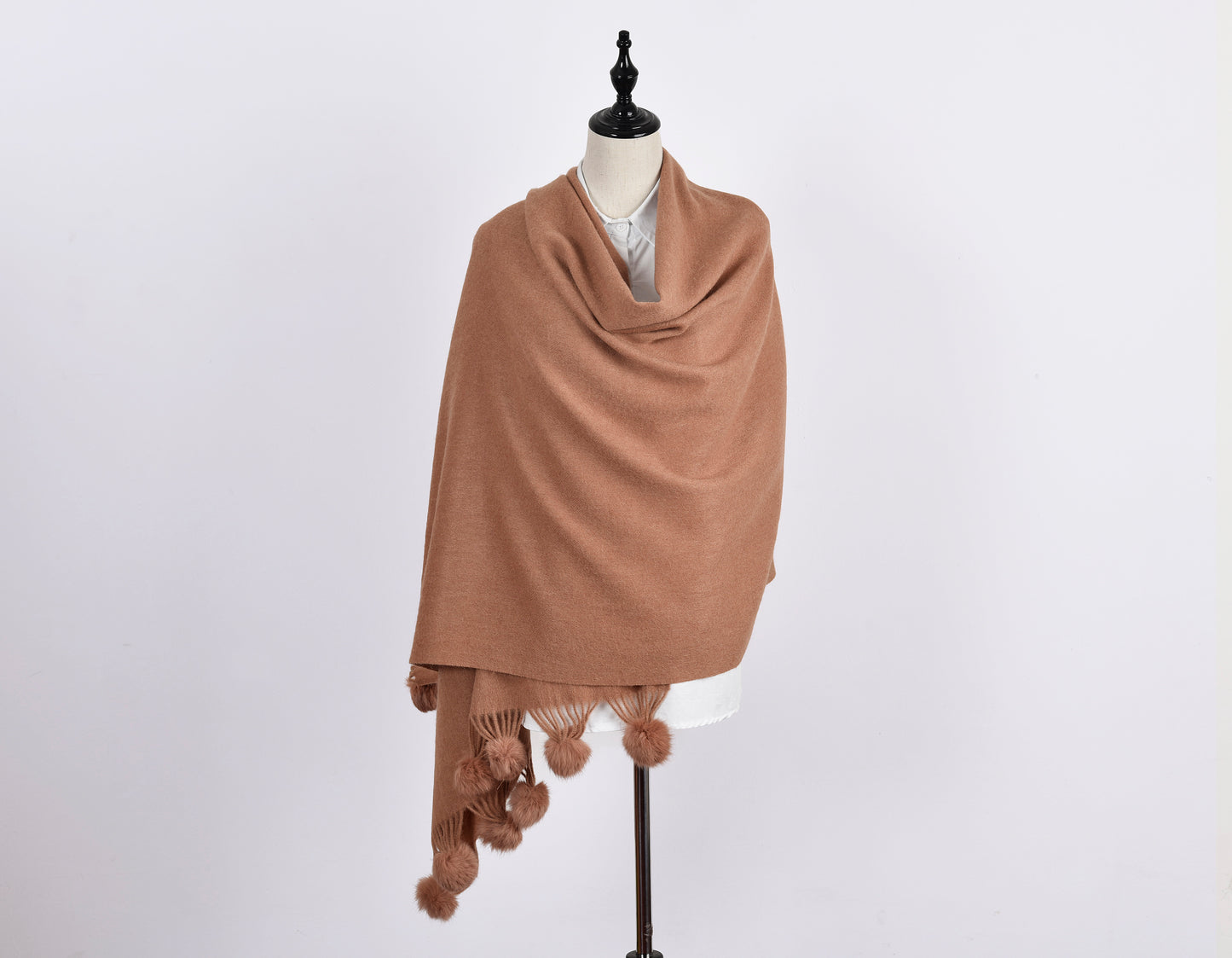 Folded pom pom scarf showing plush wool texture